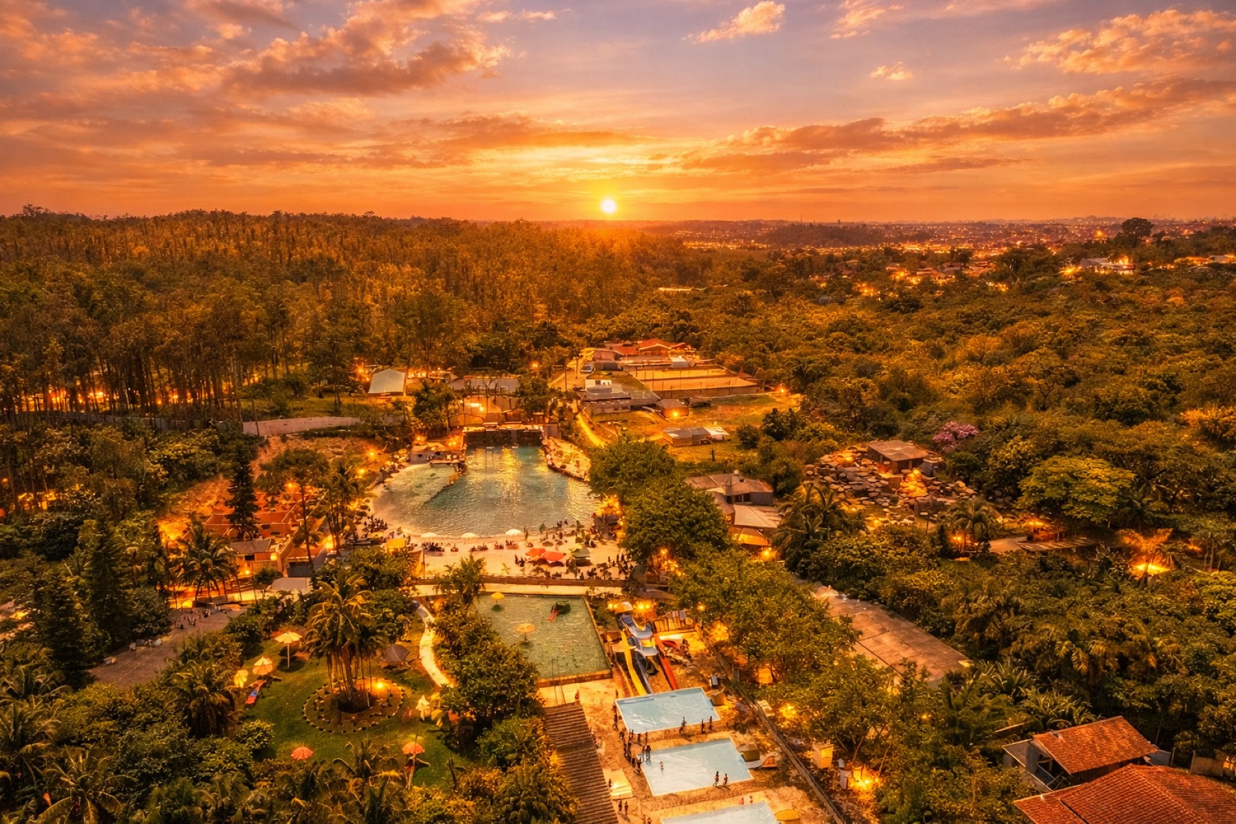 Vista aérea do Rincão Resort ao pôr do sol, com piscinas e mata ao redor